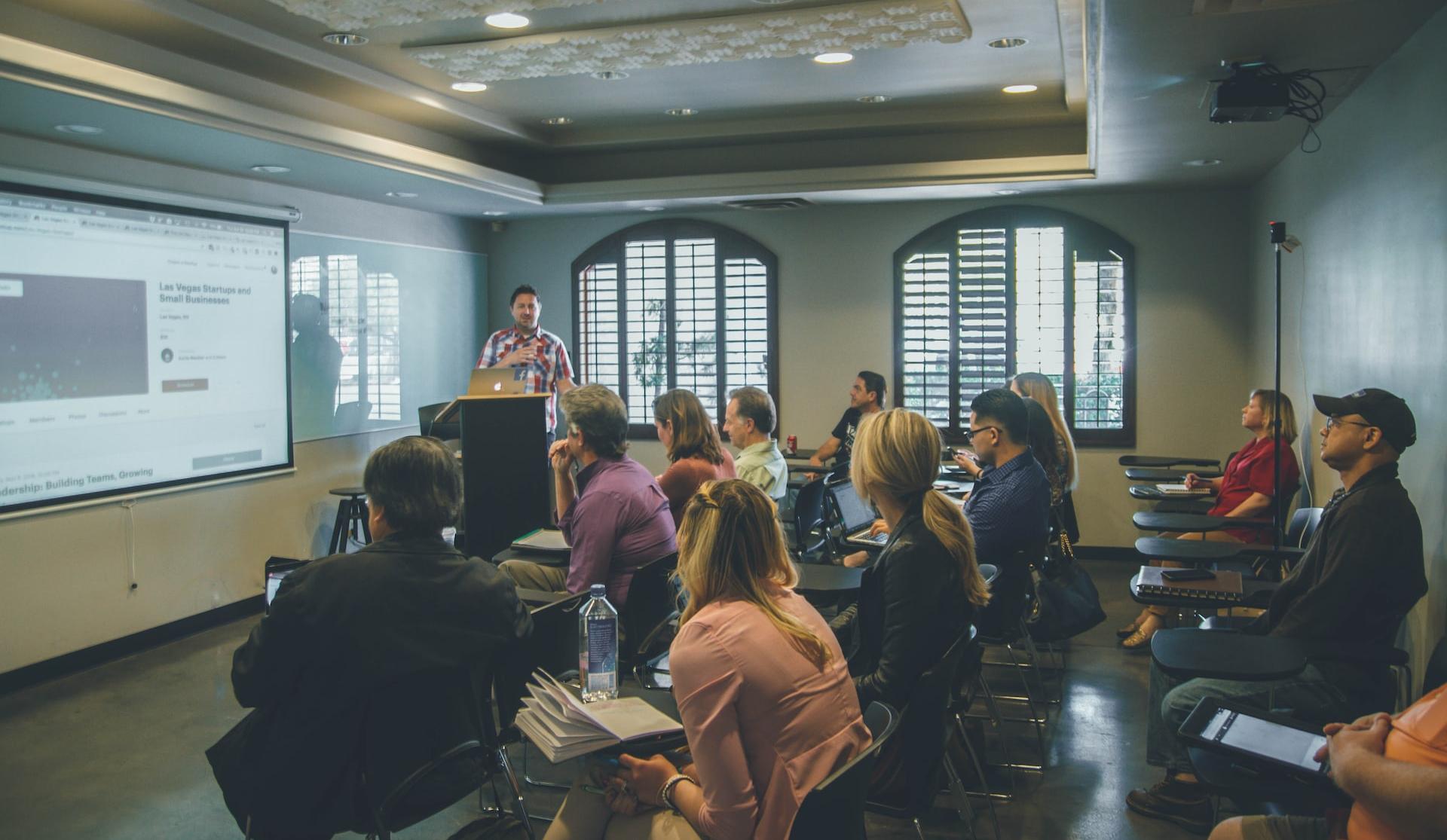 a group of people in a room with a projector screen